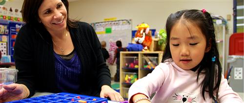 Preschool teacher working with preschool child